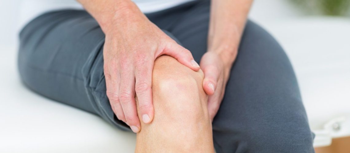 Woman having knee pain in medical office